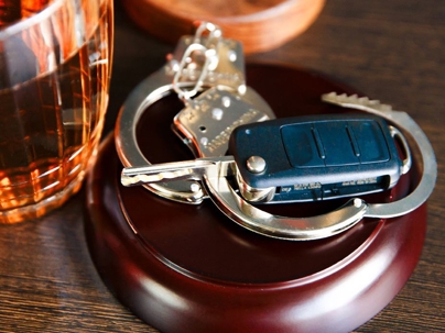 image of handcuffs, car keys, and a glass of alchohol