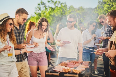 Group of people standing around grill